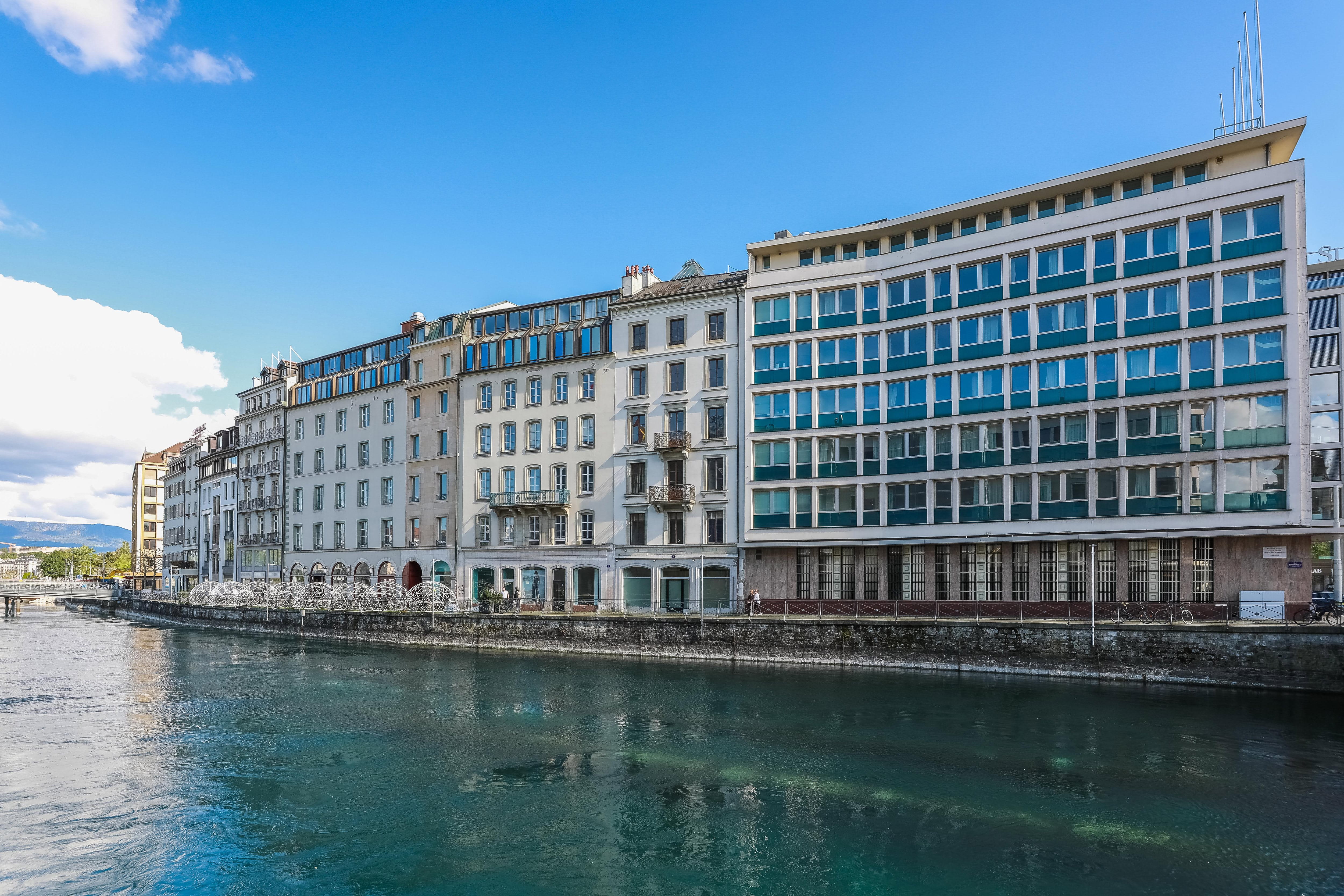 Ein Blick auf ein modernes Gebäude neben einem Wasserlauf unter blauem Himmel.