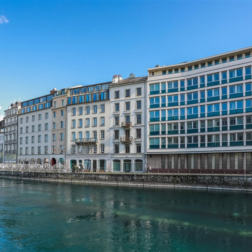 Ein Blick auf ein modernes Gebäude neben einem Wasserlauf unter blauem Himmel. Ein Blick auf ein modernes Gebäude neben einem Wasserlauf unter blauem Himmel.