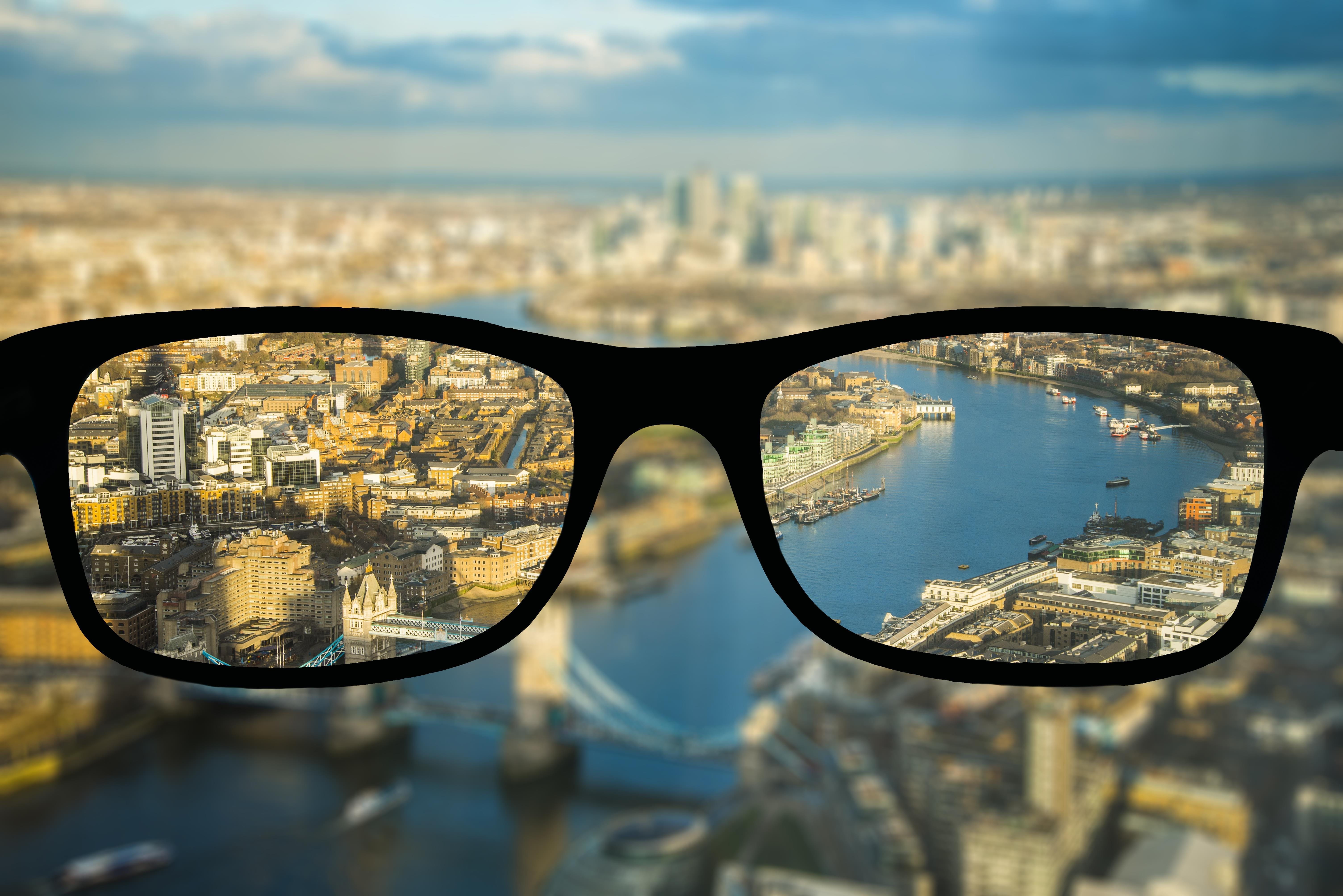 Schwarze Brille und im Hintergrund ist eine Stadt zu sehen