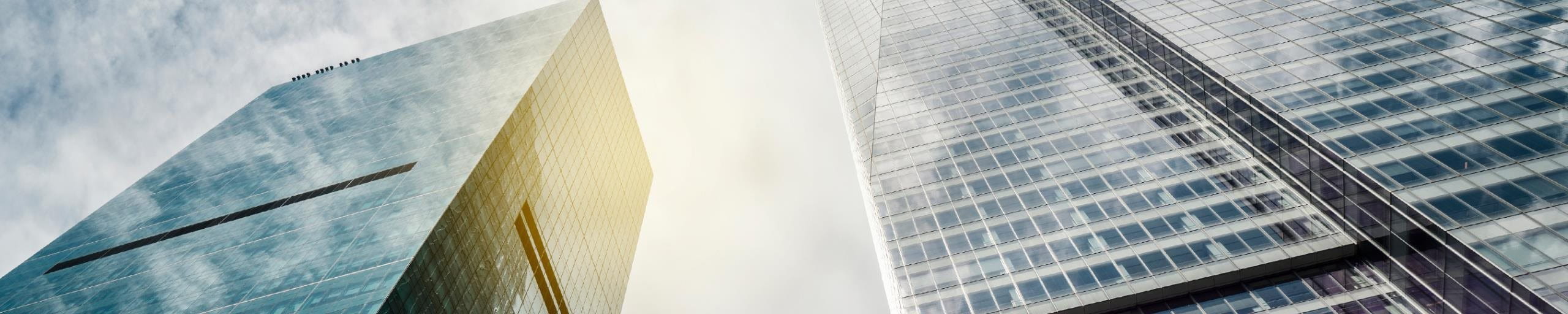 Three skyscrapers with sky and sun