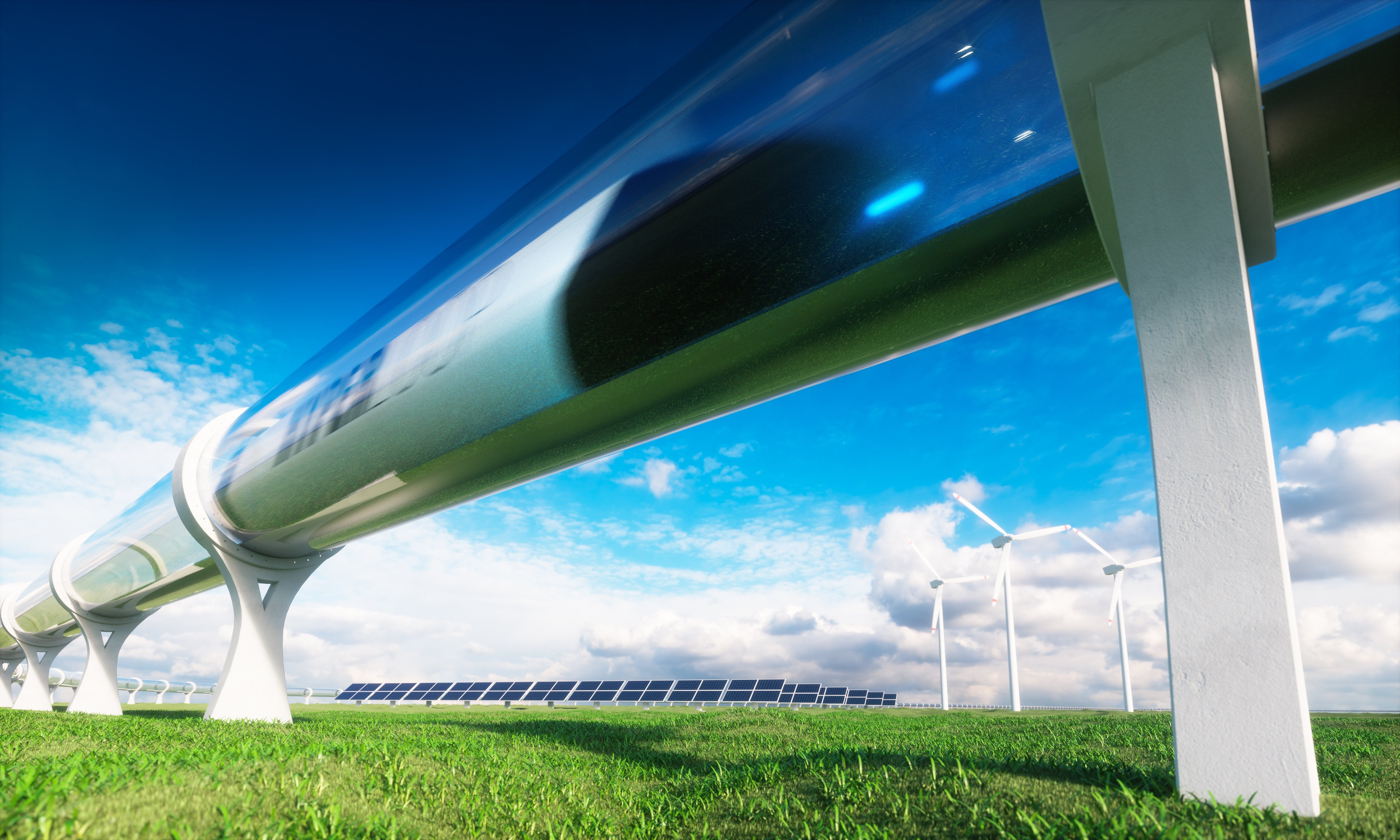 An express train passes through a housing over a green meadow