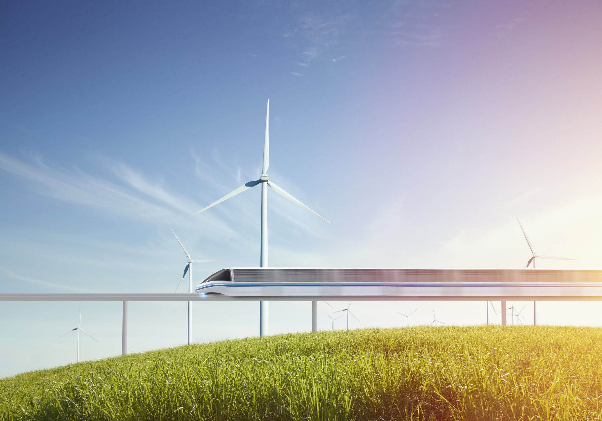 Ein fahrender Zug über einer grüne Wiese und Windräder 